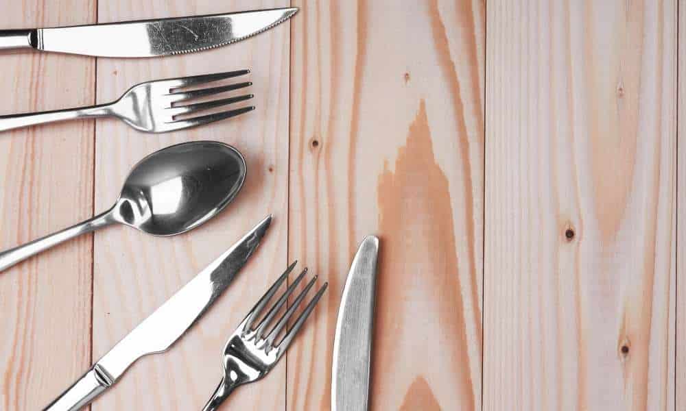 decorating a kitchen table include a knife, fork, spoon, and measuring cups. 