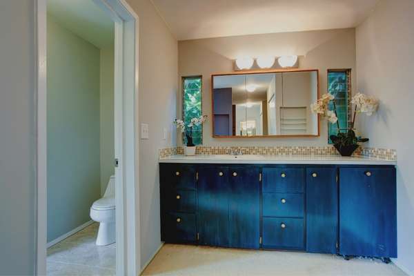 Use plenty of storage with a navy blue vanity in bathroom